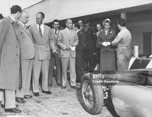 Italian race car driver and businessman Enzo Ferrari shows the former King Leopold and Princess Lilian of Belgium the latest model of the Ferrari...