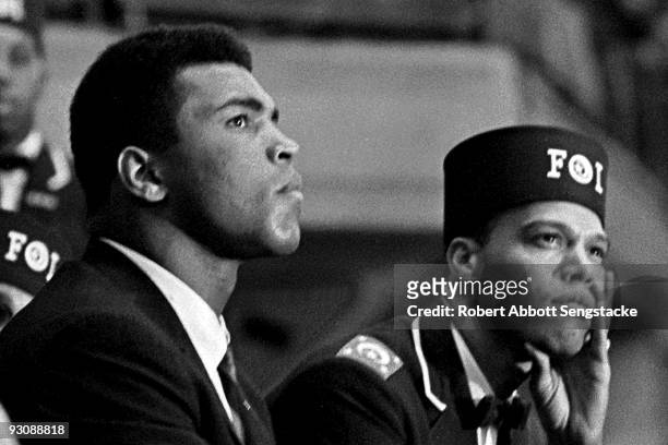 Close-up of American boxer Muhammad Ali and Nation of Islam leader Louis Farrakhan as they listen to a speaker during the Saviour's Day celebrations...