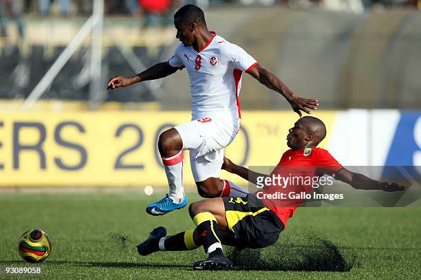 Ali Zitouni of Tunisia rides a challenge from Simao of Mozambique during the 2010 World Cup Qualifier match between Mozambique and Tunisia at the...