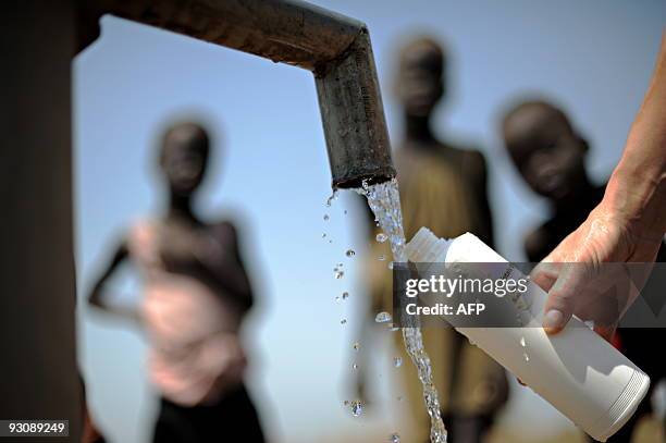 By Herve Bar - Children living in a village near the small town of Nyjaldiu in south central Sudan looks on as German hydrologist Hella Rueskamp...