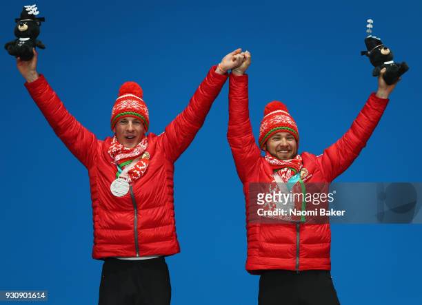 Silver medalists Yury Holub and his guide Dzmitry Budzilovich of Belarus celebrate during the victory ceremony for the Men's 20km free, visually...