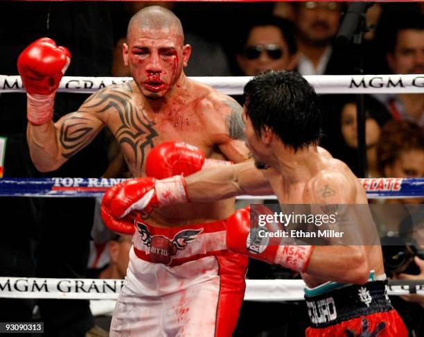 Bloodied Miguel Cotto and Manny Pacquiao battle during the 11th round of their WBO welterweight title fight at the MGM Grand Garden Arena on November...