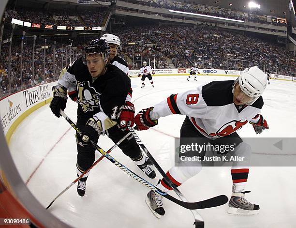 Bryce Salvador and Dainius Zubrus of the New Jersey Devils battle for a puck in the corner with Chris Bourque of the Pittsburgh Penguins at Mellon...