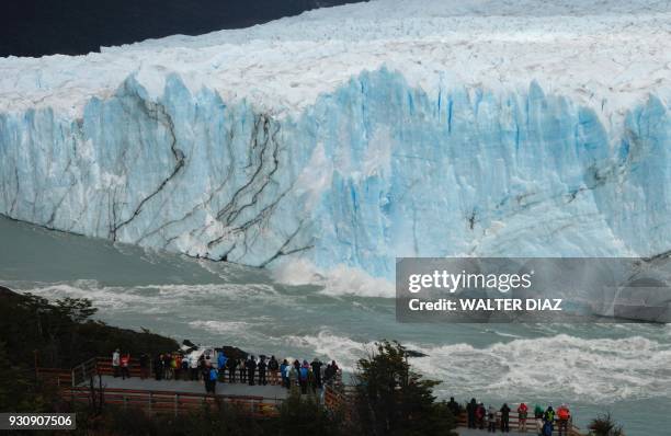 Tourist watch pieces of ice falling from the Perito Moreno glacier, at Parque Nacional Los Glaciares near El Calafate, in the Argentine province of...