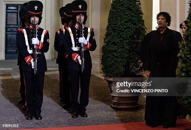Libyan leader Moamer Kadhafi walks on the red carpet upon his arrival at Chigi Palace to meet Italian Prime Minister Silvio Berlusconi in Rome on...