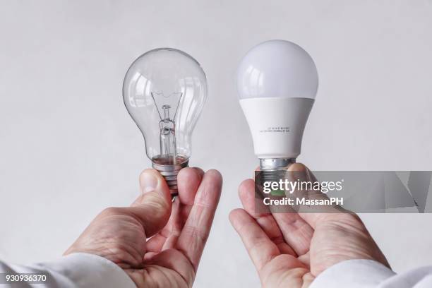 incandescent light bulb and led lamp being compared - ampoule à basse consommation photos et images de collection