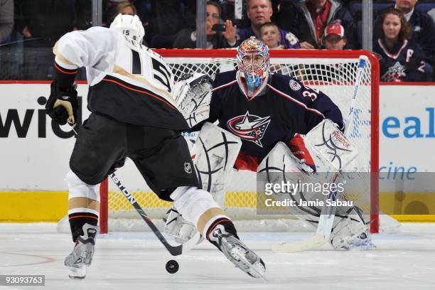Goaltender Mathieu Garon of the Columbus Blue Jackets follows forward Ryan Getzlaf of the Anaheim Ducks as Getzlaf moves in for a shoot-out attempt...