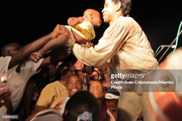 Cuban man gives his child to Cuba's Carlos Acosta of the Royal Ballet after the performance of "Manon" in the Karl Marx theatre on July 18 in Havana,...