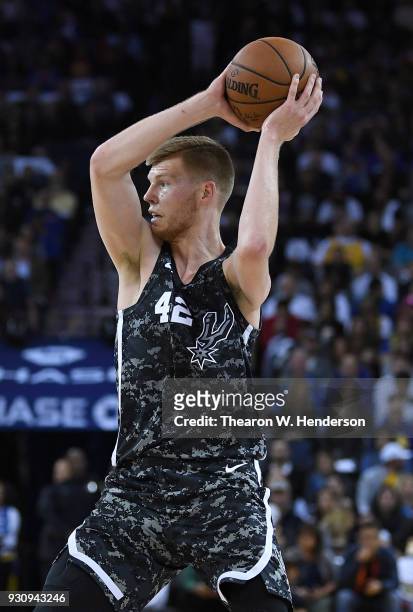 Davis Bertans of the San Antonio Spurs looks to pass the ball against the Golden State Warriors during an NBA basketball game at ORACLE Arena on...