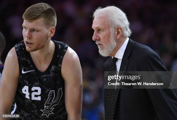 Davis Bertans of the San Antonio Spurs talks with his head coach Gregg Popovich while there's a break in the action during an NBA basketball game...