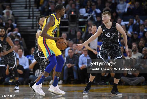 Kevin Durant of the Golden State Warriors dribbles the ball while guarded by Davis Bertans of the San Antonio Spurs during an NBA basketball game at...