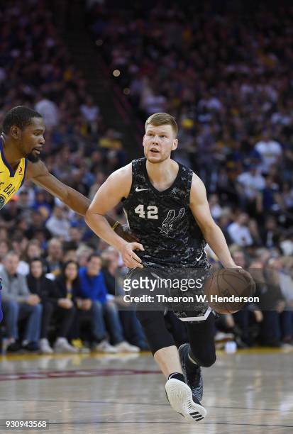 Davis Bertans of the San Antonio Spurs dribbles the ball against the Golden State Warriors during an NBA basketball game at ORACLE Arena on March 8,...