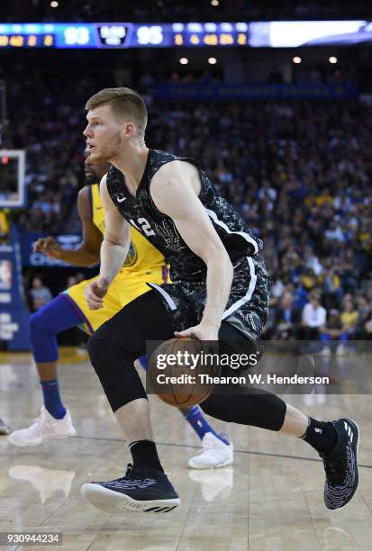 Davis Bertans of the San Antonio Spurs drives towards the baske on Kevin Durant of the Golden State Warriors during an NBA basketball game at ORACLE...