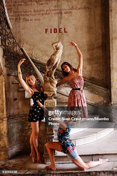 Jaqueline Clark, Laura McCulloch and Nathalie Harrison of the Royal Ballet pose for a picture under a speech of Fidel Castro in the entrance of the...