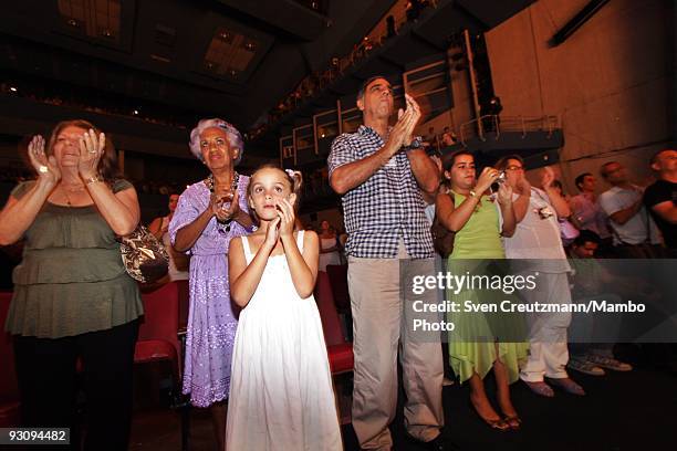 Cubans who have eventaken their children to the theatre, applaud after seeing the Royal Ballet performing "Manon" in the Karl Marx theatre on July 18...