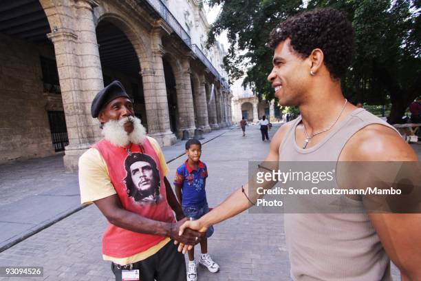 Cuban dancer Carlos Acosta of the Royal Ballet shakes hands with a cuban wearing a Che Guevera T-Shirt, in Old Havana, July 16 in Havana, Cuba. With...