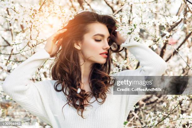 hermosa chica en el fondo de primavera arbusto - estilo de cabelo fotografías e imágenes de stock