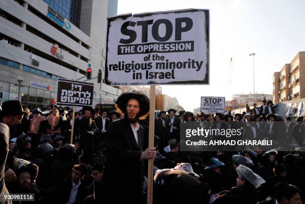 Ultra-Orthodox Jewish demonstrators block a road during a protest against Israeli army conscription in the town of Bnei Brak, near Tel Aviv, on March...