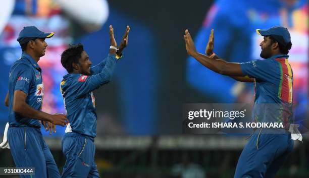 Sri Lankan cricketer Akila Dananjaya celebrates with teammates after he dismissed Indian batsman Rohit Sharma during the fourth Twenty20...