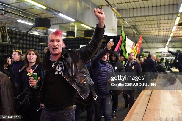 Man raises his fist during a protest against the reform of French national state-owned railway company SNCF inside Ground Control venue near the Gare...