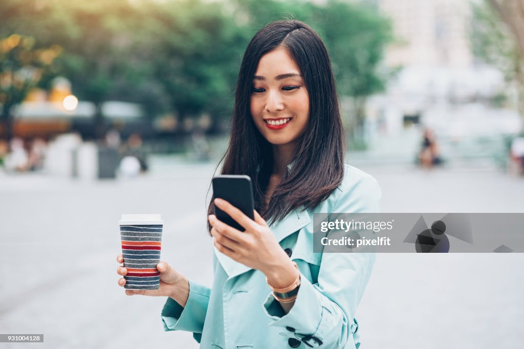 Schöne Mädchen mit Smartphone und Kaffee