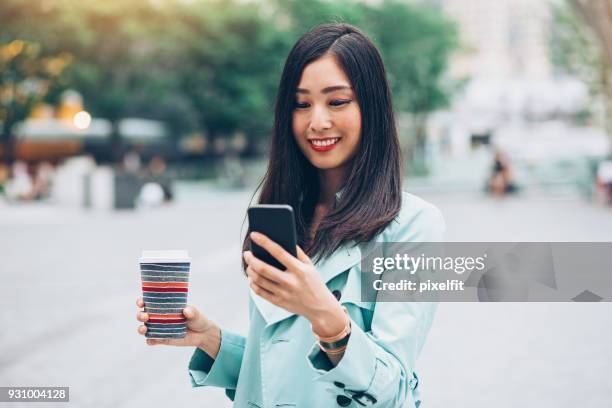 mooi meisje met slimme telefoon en koffie - lypsekyo16 stockfoto's en -beelden