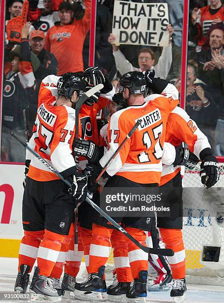 Ryan Parent, Jeff Carter, and James van Riemsdyk of the Philadelphia Flyers celebrate van Riemsdyk's third-period goal against the New Jersey Devils...