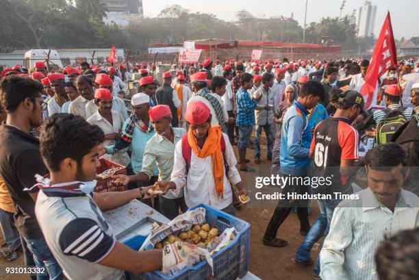 People distribute free vada pav to farmers during farmers protest march at Azad Maidan on March 12, 2018 in Mumbai, India. Over 30,000 farmers from...