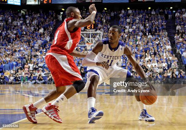 John Wall of the Kentucky Wildcats dribbles the ball while defended by Kenny Hayes of the Miami University Redhawks during the game at Rupp Arena on...