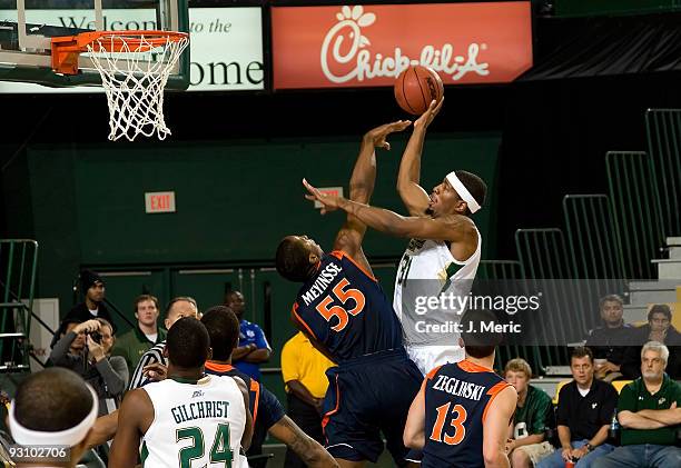 Forward Jarrid Famous of the South Florida Bulls shoots over forward Jerome Meyinsse of the Virginia Cavaliers during the game at the SunDome on...