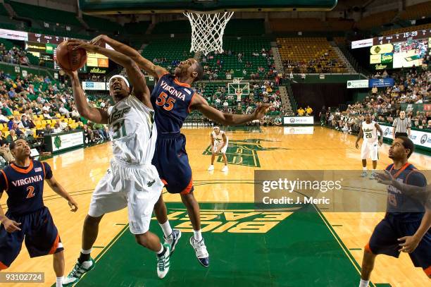 Forward Jarrid Famous of the South Florida Bulls shoots over forward Jerome Meyinsse of the Virginia Cavaliers during the game at the SunDome on...