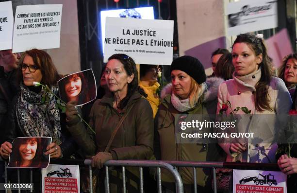 Women from feminist organizations, some holding pictures of late French actress Marie Trintignant , and a placard reading "Justice does not rule on...