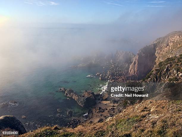 sea fog shrouds rugged cliffs - island of alderney photos et images de collection