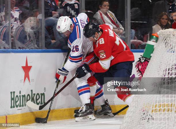 Jimmy Vesey of the New York Rangers and Maxim Mamin of the Florida Panthers battle for possession of the puck at the BB&T Center on March 10, 2018 in...