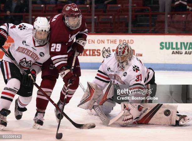 Northeastern Huskies goaltender Cayden Primeau makes the save as Massachusetts Minutemen forward George Mika moves in during the first period....