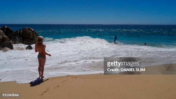 Tourist sunbathes on the seashore at the "Love Beach" in Los Cabos, Baja California Sur state, Mexico on March 10, 2018. Despite a surge of violent...