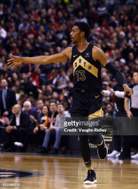 Malcolm Miller of the Toronto Raptors high fives a teammates during the first half of an NBA game against the Houston Rockets at Air Canada Centre on...