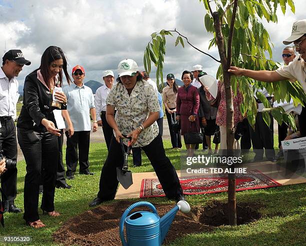 Princess Maha Chakri Sirindhorn of Thailand replaces soil at the base of a newly planted tree at the International Rice Research Institute in the...