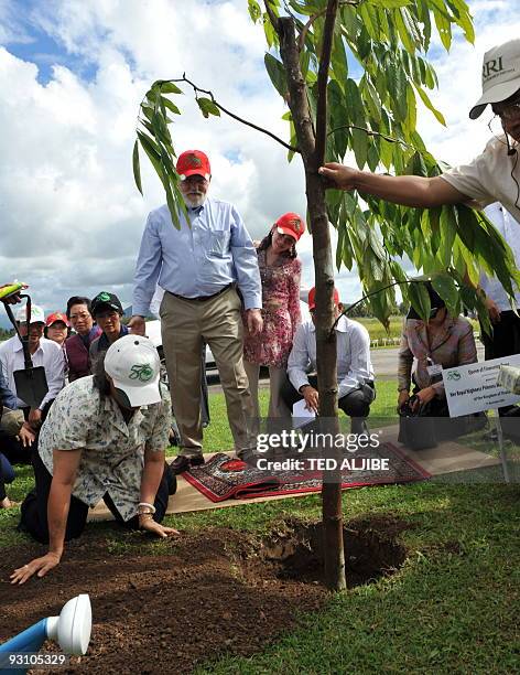 Princess Maha Chakri Sirindhorn of Thailand replaces soil at the base of a newly planted tree at the International Rice Research Institute in the...