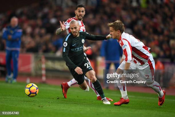 David Silva of Manchester City evades Geoff Cameron and Moritz Bauer of Stoke City during the Premier League match between Stoke City and Manchester...