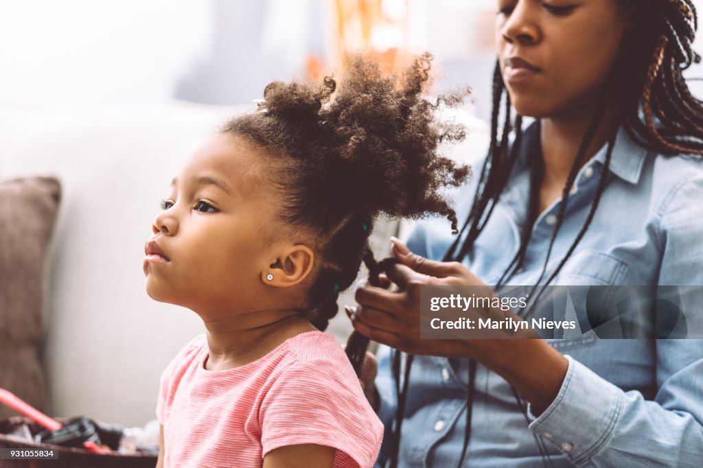 Mother styling daugher's hair