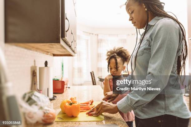 mother and daughter cutting vegetables - marilyn nieves stock pictures, royalty-free photos & images