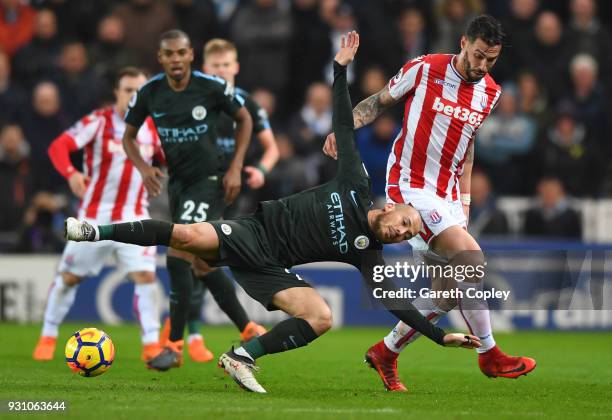 David Silva of Manchester City is challenged by Geoff Cameron of Stoke City during the Premier League match between Stoke City and Manchester City at...