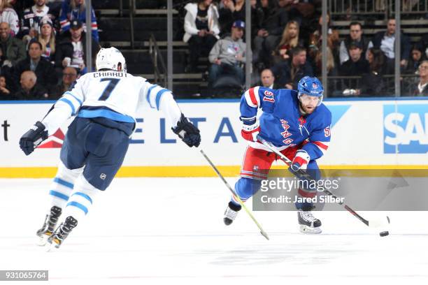 David Desharnais of the New York Rangers skates with the puck against Ben Chiarot of the Winnipeg Jets at Madison Square Garden on March 6, 2018 in...