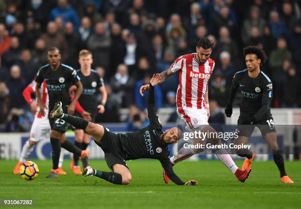 David Silva of Manchester City is challenged by Geoff Cameron of Stoke City during the Premier League match between Stoke City and Manchester City at...