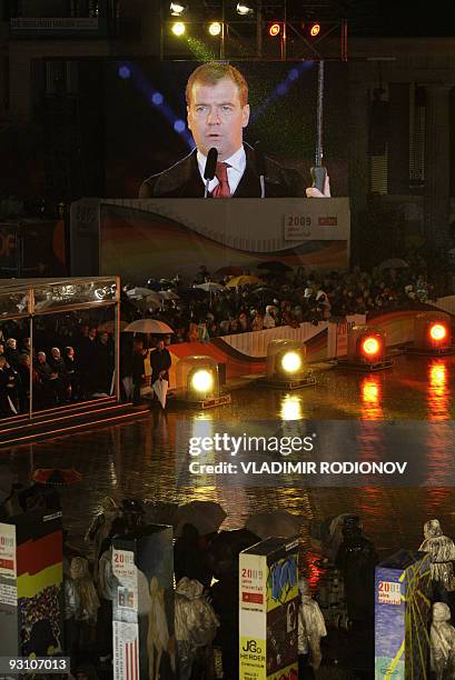 Russian President Dmitry Medvedev is seen on a giant TV screen while making a speech near the Brandenburg Gate in Berlin on November 9, 2009 during...