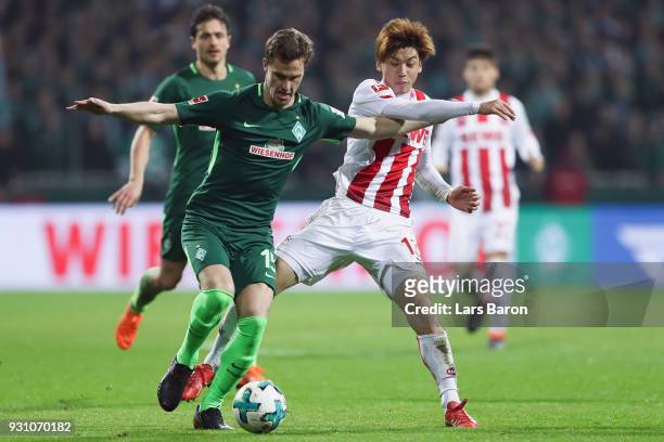 Sebastian Langkamp of Bremen is challenged by Yuya Osako of Koeln during the Bundesliga match between SV Werder Bremen and 1. FC Koeln at...