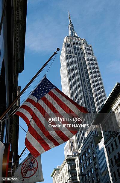 An American Flag flies at half staff near the Empire State Building 15 September 2001 in New York. The 443-meter tall building is now the tallest...