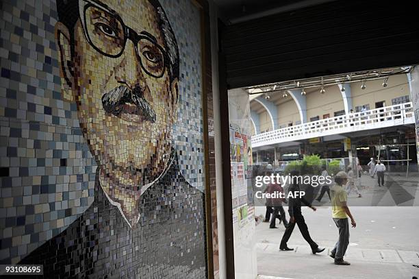 Bangladeshis walk past a mosaic of Bangladesh�s founding president Sheikh Mujibur Rahman in Dhaka on November 17, 2009. Rahman was murdered at home...