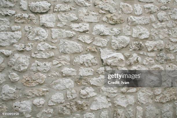 full frame texture, wide shot of a plain limestone wall - stützmauer stock-fotos und bilder